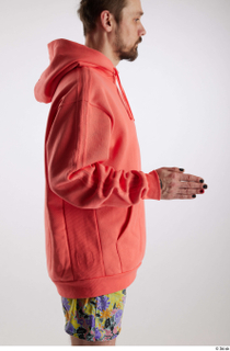 Nigel 1 arm dressed flexing salmon hoodie sweatshirt side view…